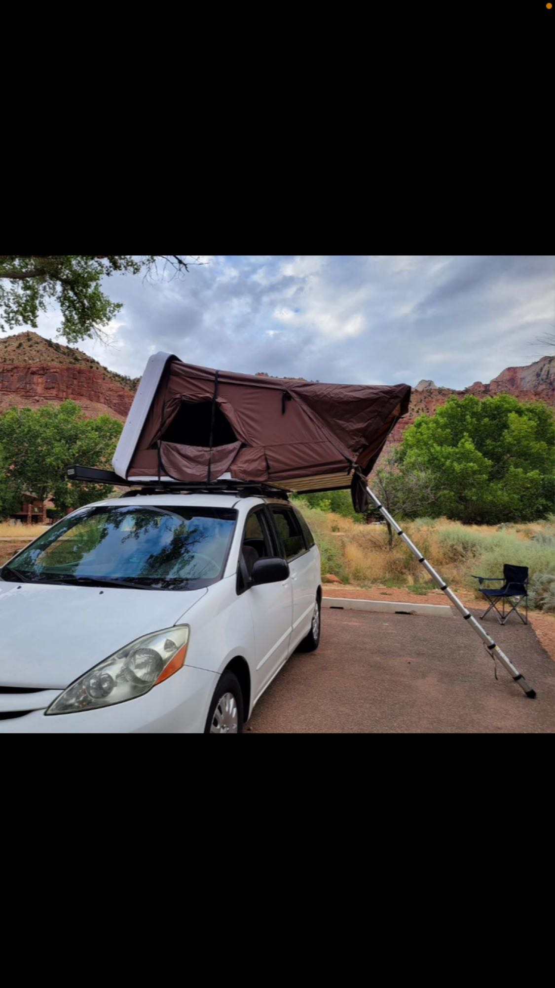  and comfy chairs.|White minivan with rooftop tent & chairs set up — photo 3