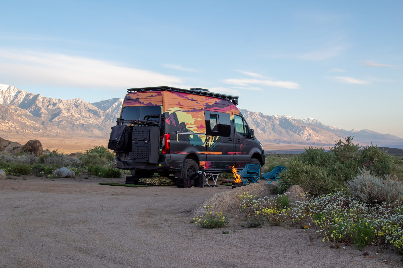  backed by snowy mountains.|This colorful RV rental is perfectly set up for a desert camping adventure with a fire pit and mountain views.|This vibrant RV rental is parked at a desert campsite — photo 6
