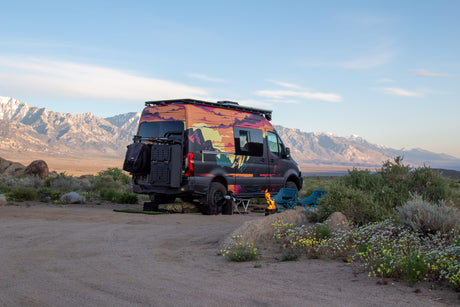 This colorful RV rental is perfectly set up for a desert camping adventure with a fire pit and mountain views.