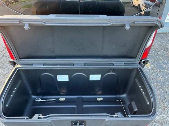 RV rental's open rear storage box, an empty black plastic cargo compartment, ready for your gear.