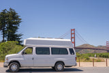 White high-top RV rental van parked near the iconic Golden Gate Bridge, ideal for scenic travels.