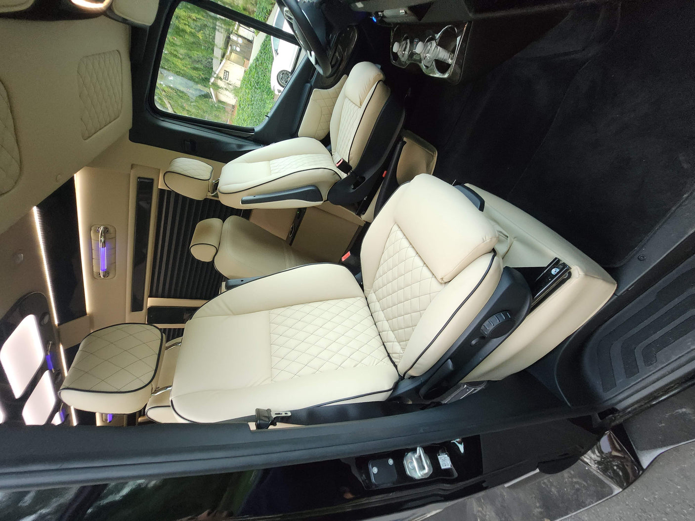 Luxurious RV rental interior: cream quilted leather seats, ambient lighting. Perfect for comfortable travel.