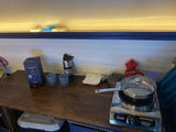 RV rental cooking and dining station: Sportsman camping stove, Nighthawk wine, and coffee maker on a wooden counter.