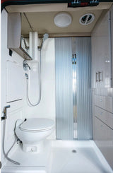 RV rental bathroom: Compact, all-white design with integrated toilet, handheld shower, and smart storage solutions.