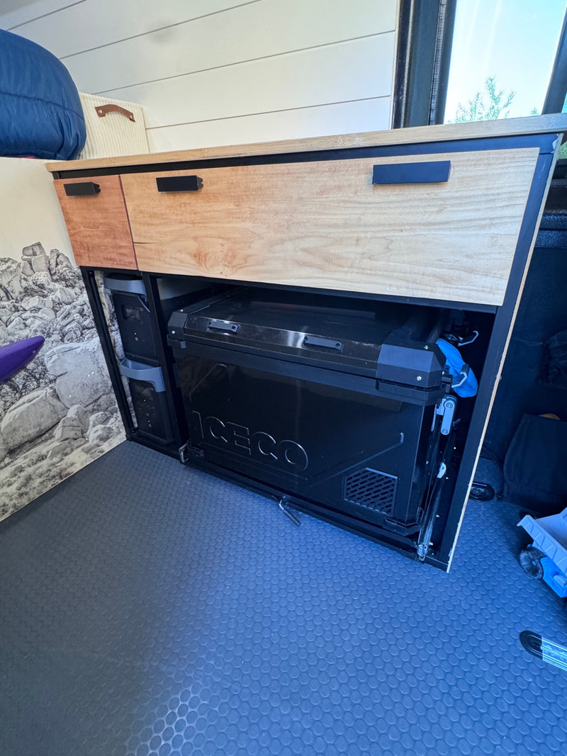 RV rental: Efficient wooden cabinet with pull-out ICECO fridge and organized storage in a camper interior. — photo 6