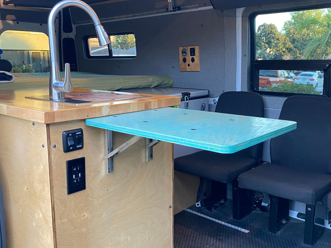 RV rental interior featuring a kitchenette with sink, pull-out dining table, and seating. — photo 15