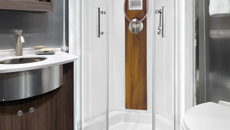 Explore the efficient design of this RV rental bathroom, featuring a compact sink, modern shower, and toilet for comfortable journeys.