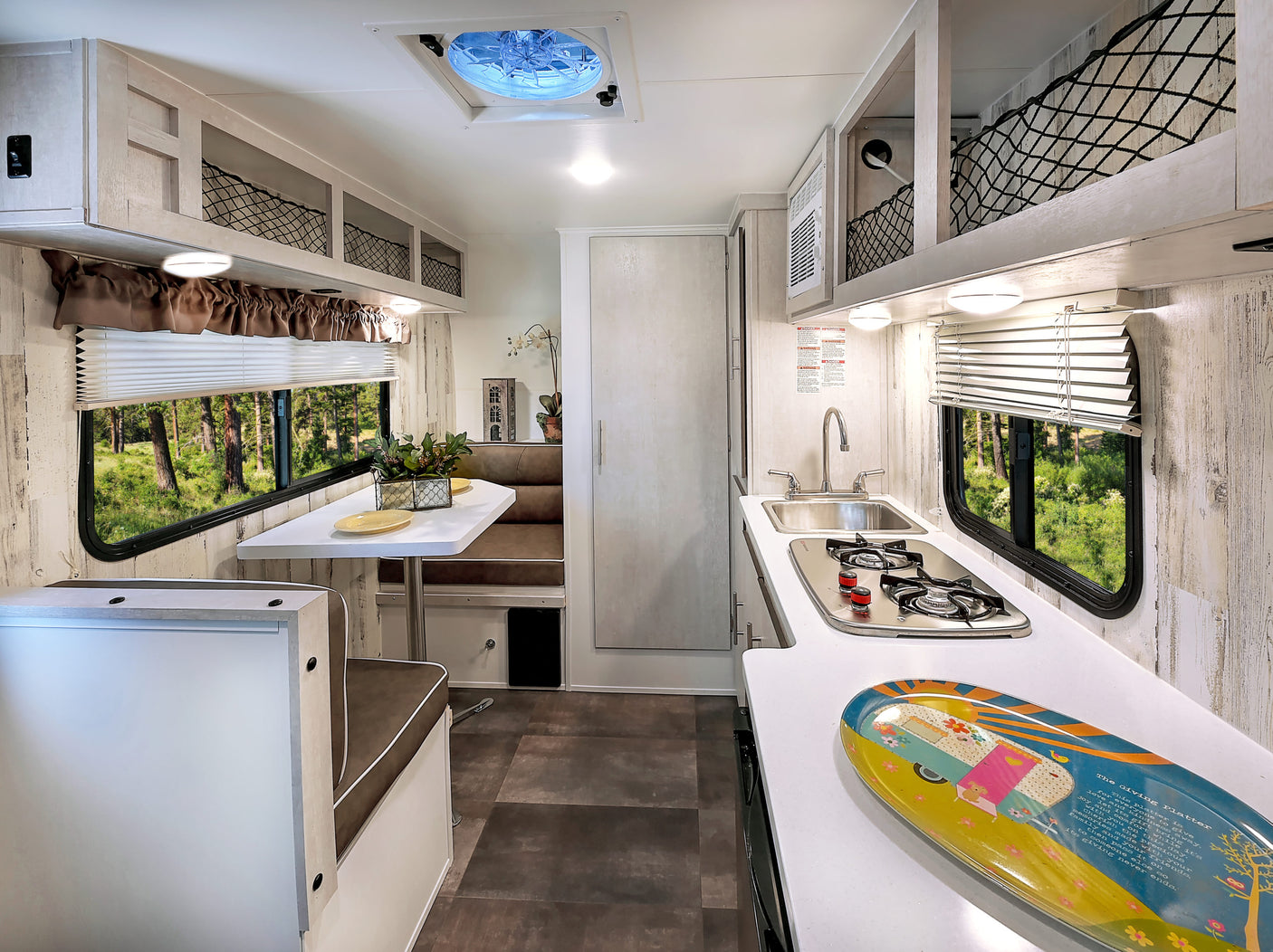 Step inside this RV rental! Enjoy a bright interior with a dining booth, functional kitchenette, and beautiful window views.