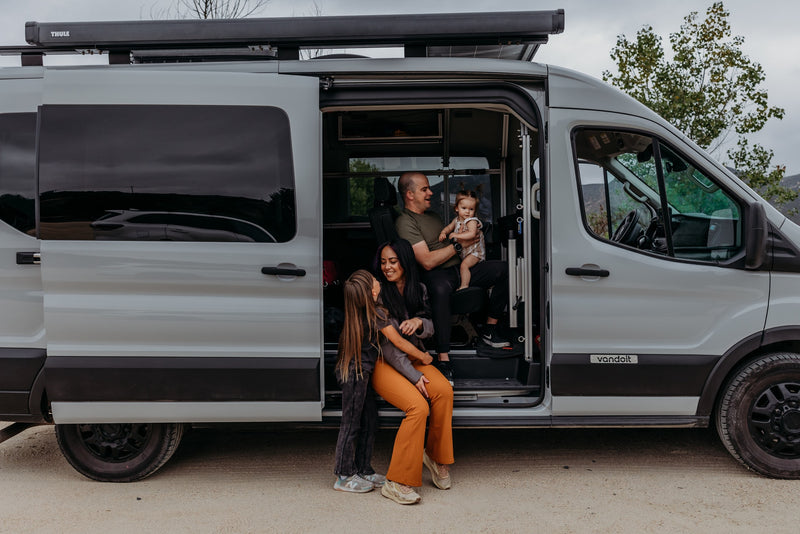 Family moments in a spacious RV rental camper van. Dad holds baby, while mom and daughter relax by the open door. — photo 19