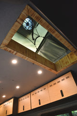 RV rental interior: Looking up at a ceiling with a fan/roof vent, mesh storage, recessed lighting, and wooden overhead cabinets.