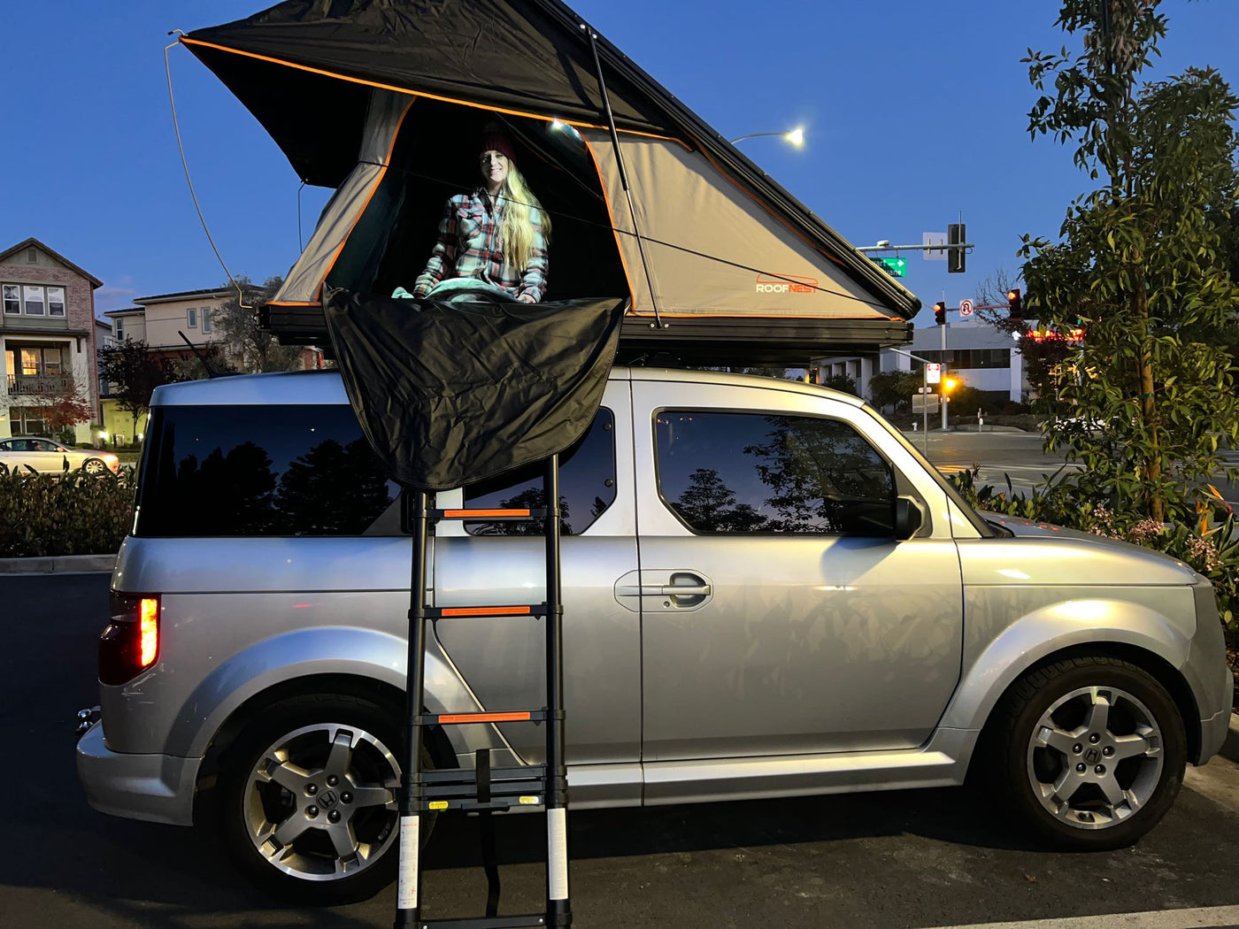  perfect for RV rental trips.|A woman inside a car-top tent on a silver Honda Element — photo 5