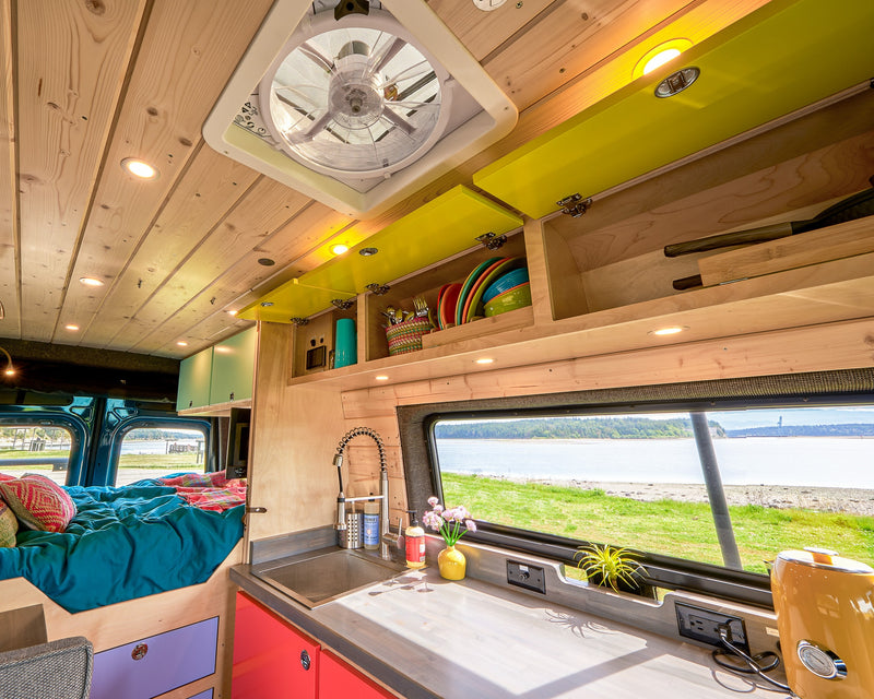 Modern RV rental interior with bright kitchen, cozy bed, and scenic bay view. — photo 12