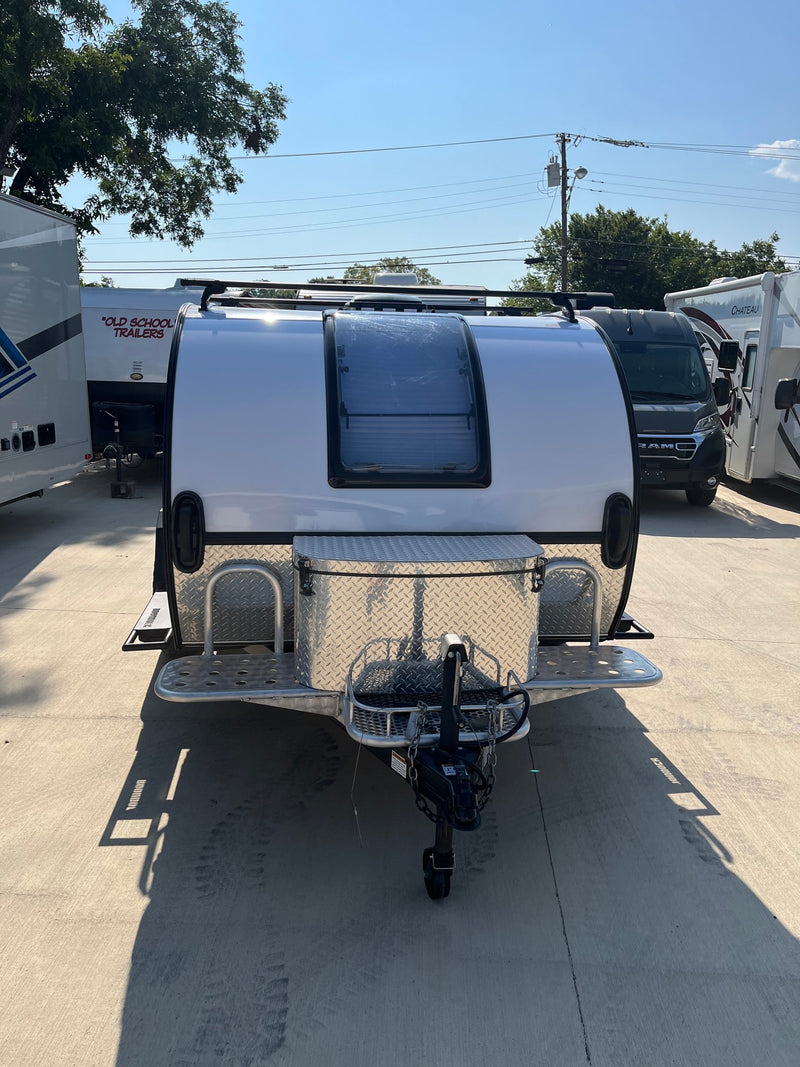 White teardrop trailer with large front window & diamond plate storage, perfect for rv rental. Sunny lot. — photo 4