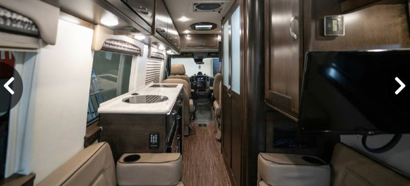  featuring a convection oven and full control panel.|Compact Norcold stainless steel refrigerator with minor scratches in an RV rental for your travels.|Interior of a compact — photo 5