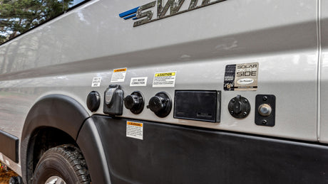 This RV rental shows detailed external utility hookups for electrical, water, cable/satellite, and solar power connections.