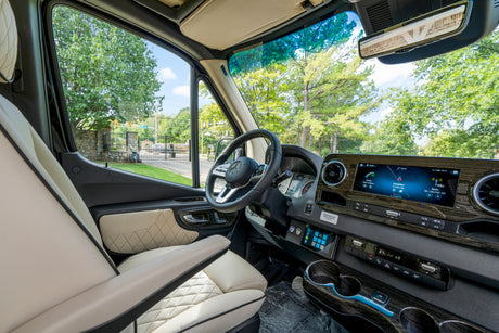 Explore this modern rv rental's cockpit: plush seats, wood-grain dashboard, and advanced infotainment with navigation.