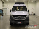 Silver Mercedes-Benz Sprinter RV rental parked indoors. This versatile camper van is perfect for your next adventure.