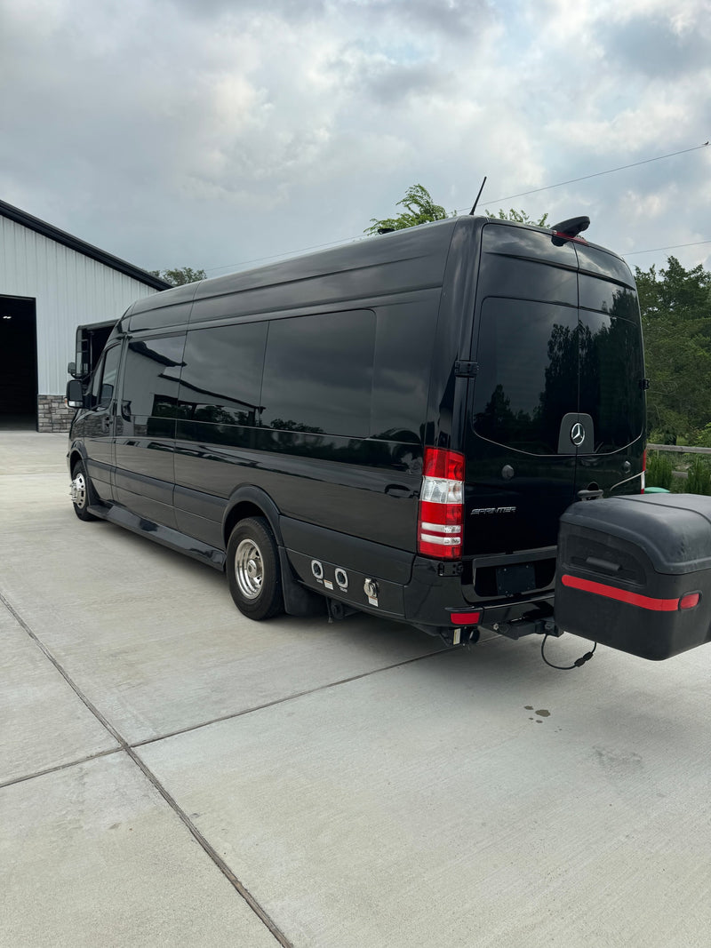 Rear view of a black Mercedes-Benz Sprinter RV rental featuring dual rear wheels and a hitch-mounted storage box. — photo 4