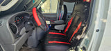 Inside an RV rental van: driver's seat with red/black covers, dashboard, and steering wheel visible.