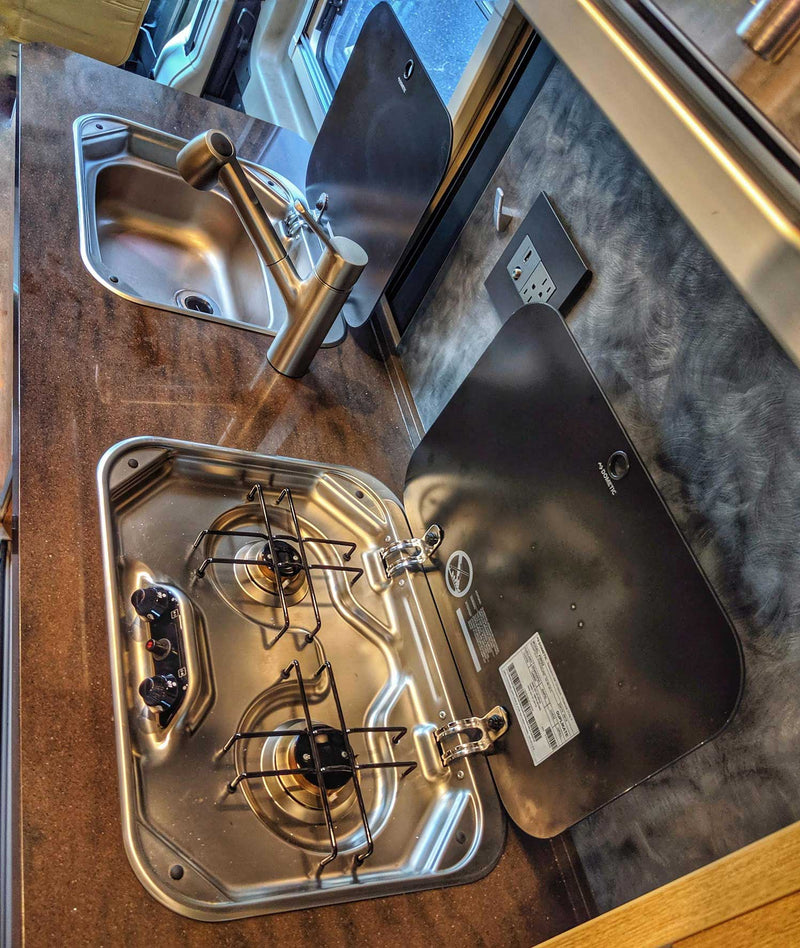  and a cozy bed by a window with a dock view.|This rv rental showcases a modern interior with tan seats — photo 8