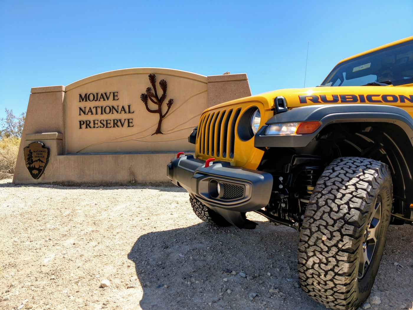  parked by a clear stream reflecting its image and surrounding forest. Ideal for an rv rental outdoor trip.|Yellow Jeep Wrangler Rubicon with rooftop tent on a scenic mountain off-road trail. Perfect for RV rental adventures!|A yellow Jeep Rubicon — photo 12