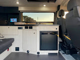 Explore a modern RV rental: well-appointed camper van interior with compact kitchen, control panel, and seating area.