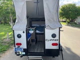 Explore the interior of this Clipper pop-up rv rental, featuring a bed, kitchen area, and Montana license plate.