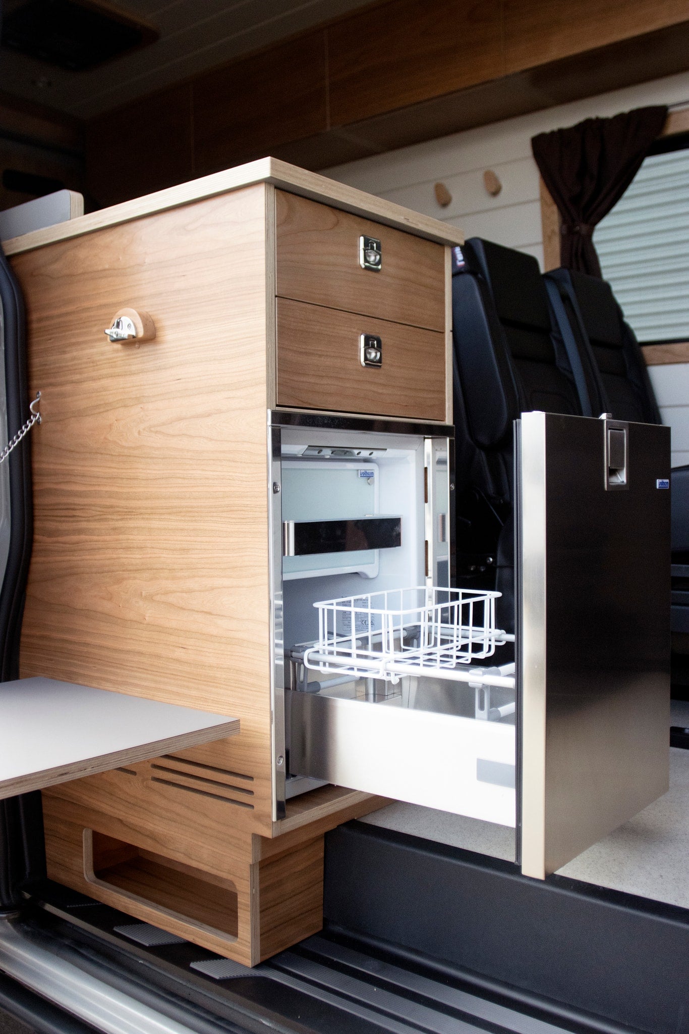  and rear passenger seats for travel.|Red-cushioned bench and storage unit in an RV rental interior. Features wood and white paneled walls — photo 2
