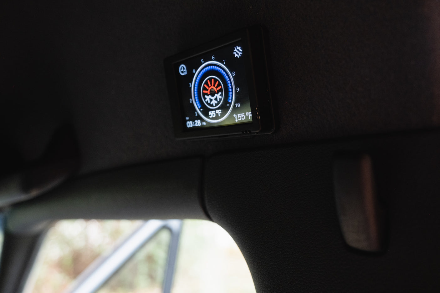 RV rental: Digital climate control panel in a camper interior, showing 55°F, 155°F heating, time, and fan speed settings.