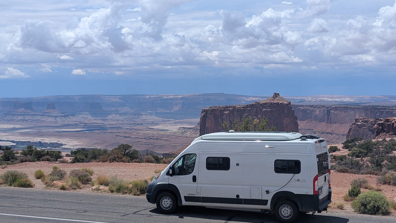  and people enjoying the sand.|White Solis rv rental parked on a winding coastal road — photo 7