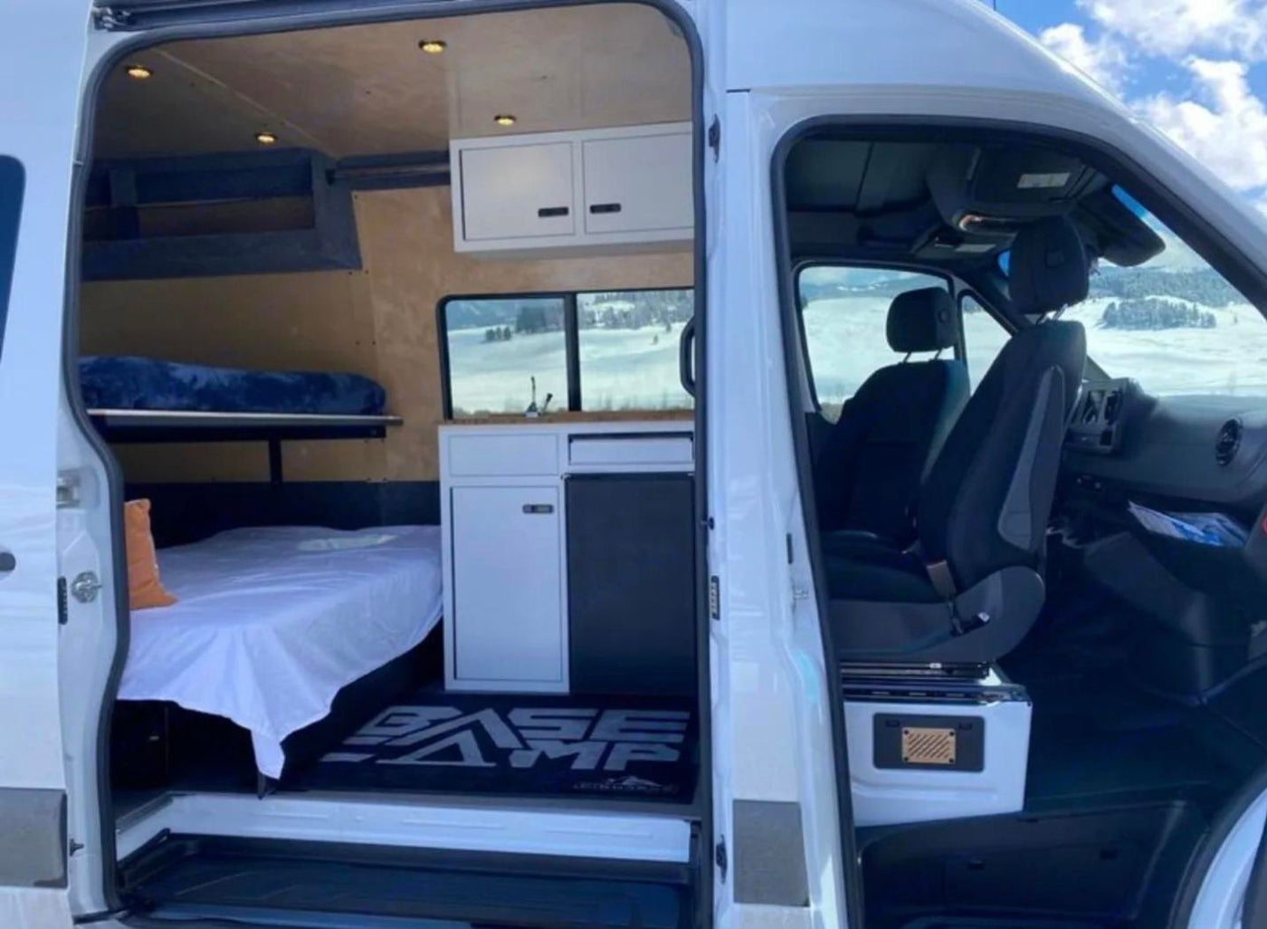  & driver's area. Snowy landscape visible outside.|RV rental: Cozy camper van under a starry — photo 3