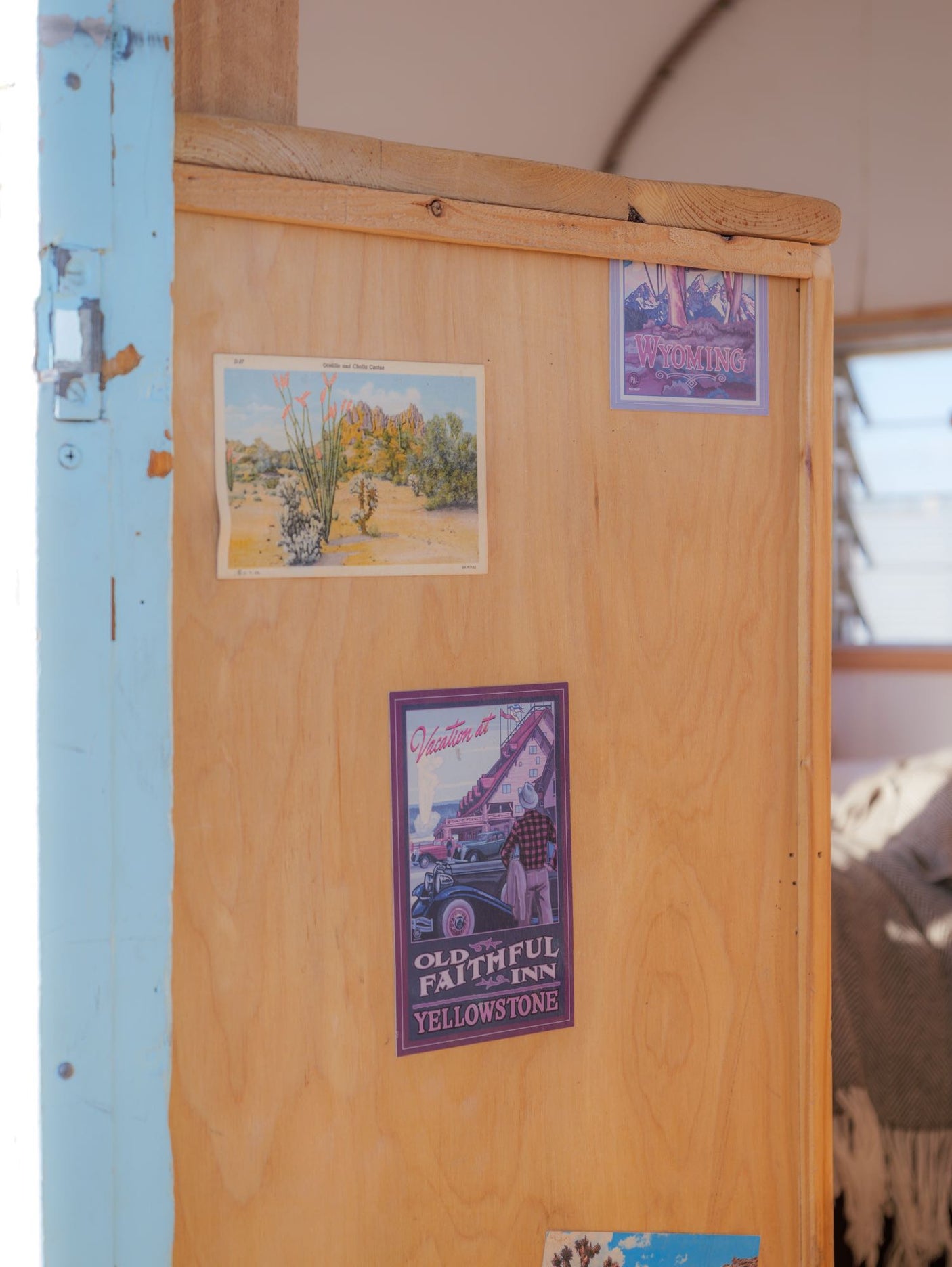 RV rental interior showcases travel-themed decor: a desert postcard, Wyoming sticker, and Yellowstone Old Faithful Inn poster.