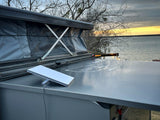 RV rental with a pop-up tent and Starlink dish, providing internet by a lake at sunset.