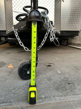 Measuring RV rental trailer tongue jack height at 12 inches (1 foot) with a tape measure, crucial for proper hitching.