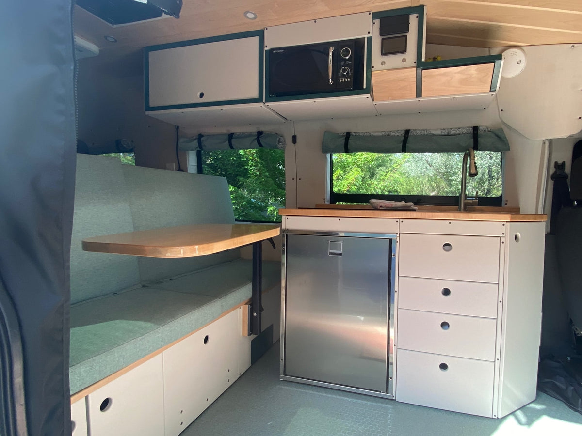  and peaches box on counter. Scenic mountain view outside.|Cozy RV rental interior: kitchenette with fridge — photo 5