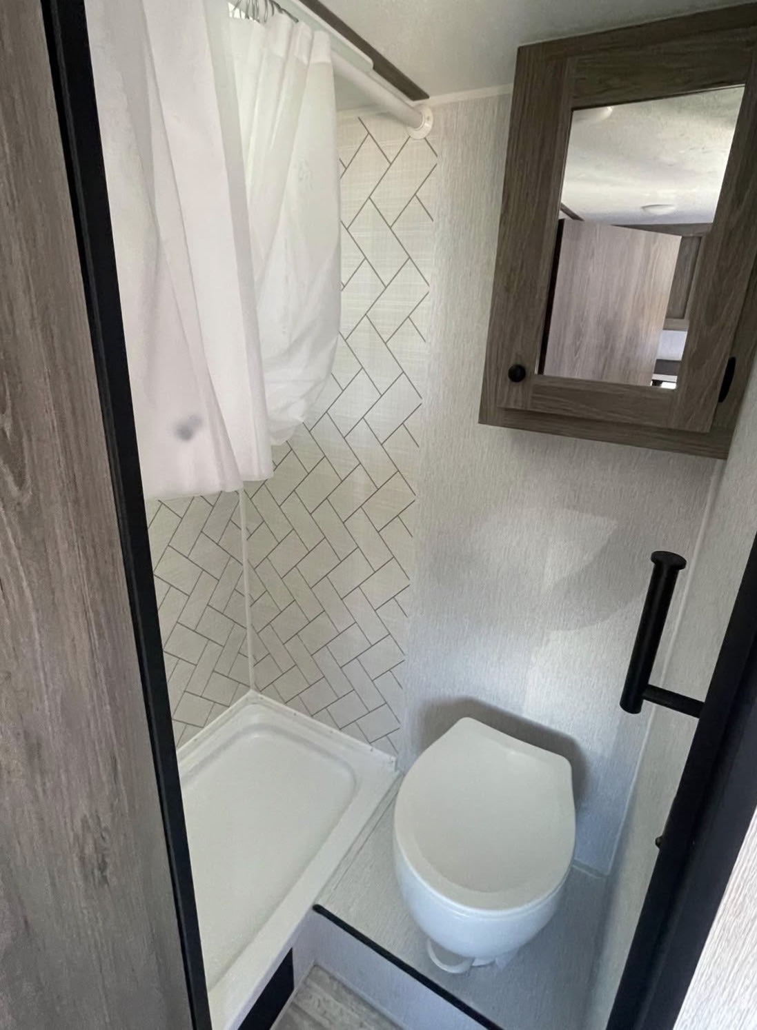  this clean shower features white walls with a herringbone pattern