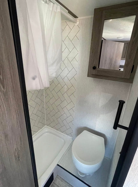  this clean shower features white walls with a herringbone pattern