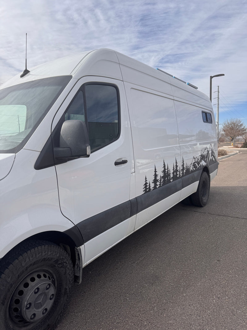White camper van with nature (trees & mountains) decals on side, parked on asphalt. Ready for your RV rental adventure. — photo 5