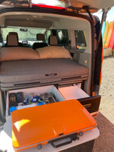 Compact rv rental camper setup features a comfy bed, pull-out kitchen, fridge, and portable stove. Ready for adventure!