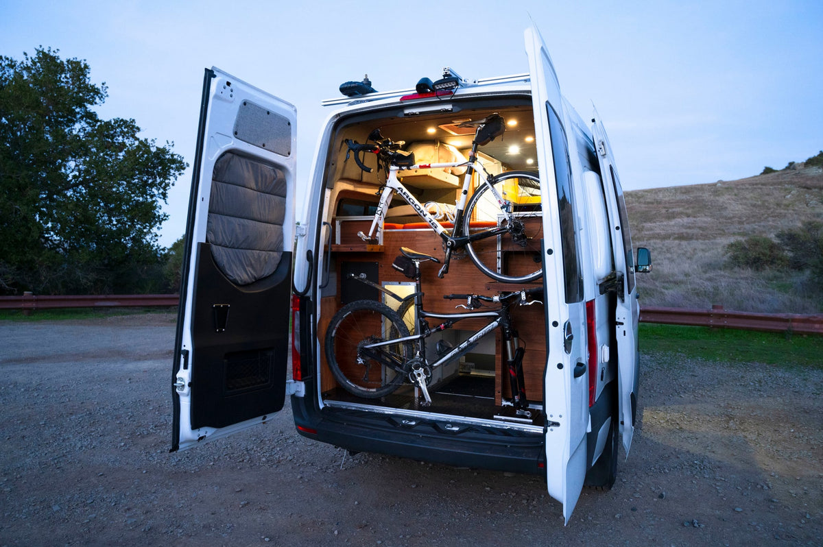  and compact kitchen sink for comfortable travel.|Cozy RV rental interior with a large red bed — photo 17