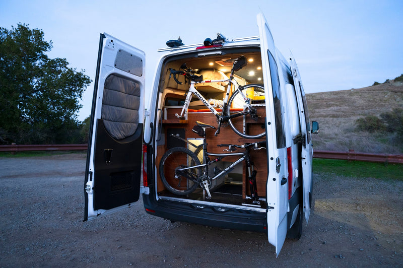  and compact kitchen sink for comfortable travel.|Cozy RV rental interior with a large red bed — photo 17
