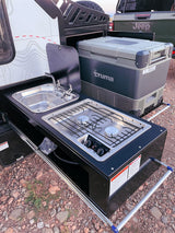RV rental outdoor kitchen setup with Dometic stove, sink, and Truma fridge, perfect for camping adventures.