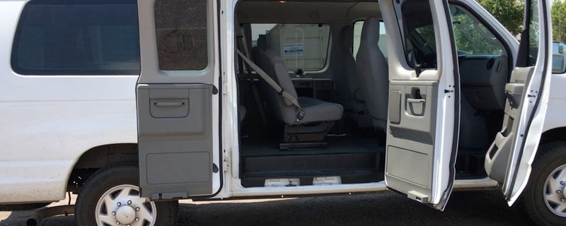  driver's door open. Ideal for RV rental. Parked in a service lot.|White Ford passenger van — photo 3