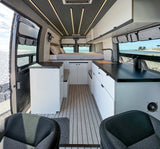 Step inside this modern RV rental camper van. Enjoy a full bed, kitchen, ample storage, and breathtaking water views through open doors.