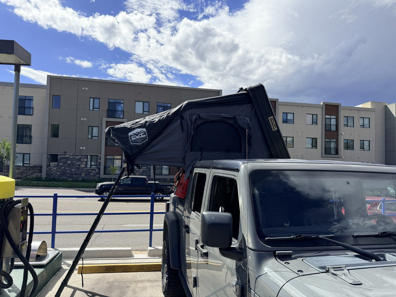 Rooftop tent fully opened on the truck, wide side view with ladder down — photo 2