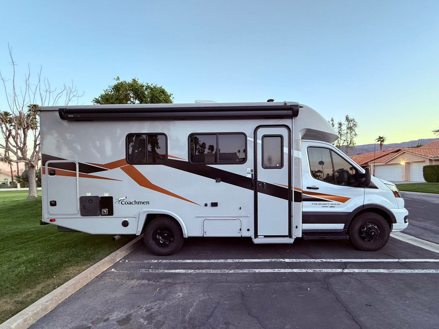 RV rental: A white & gray Coachmen Transit 250HD AWD motorhome parked outdoors, ready for travel.