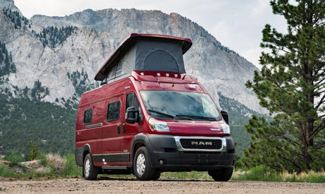 Red pop-top camper van for RV rental outdoor adventures, set against a stunning mountain backdrop.