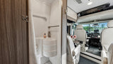 RV rental interior: compact bathroom with shower/sink, leading to front cockpit with swivel seats. Ready for your next road trip!