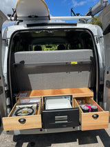 This RV rental features a compact pull-out kitchen with stove, fridge, and a surfboard on the roof rack. Adventure-ready!