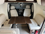Inside a bright RV rental, featuring the front seats, a central table, and comfortable side benches.